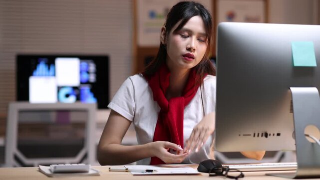 Young woman experiencing stress while working late at office. Businesswoman experiencing intense workplace stress, struggling with overwhelming workload and looming project deadlines.