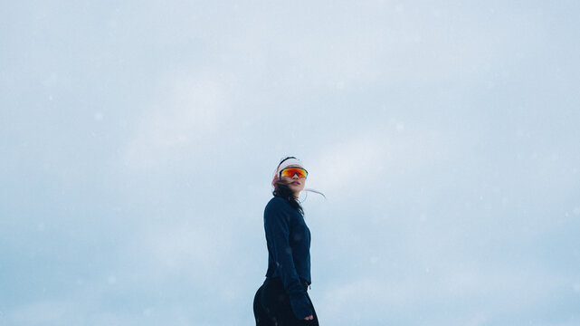 Strong woman athlete poses confidently in snowy winter landscape