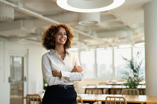 Smiling american business woman standing for portrait in coworking office workplace, looking at camera. In 30s, female broker works as accountant, employee, staff, worker, professional. Copy space