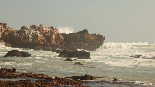 waves rolling into rocky coastline of Kammabaai Beach, Hermanus, South Africa