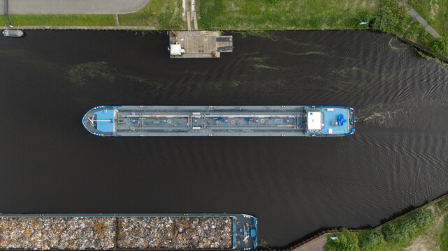 Aerial top-down view of a cargo barge navigating a canal