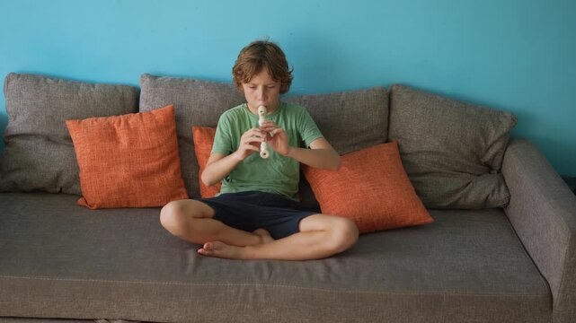 A little boy learns to play the flute at home, practicing with focus and enthusiasm in a cozy, warm setting. A charming scene of early musical exploration, creativity, and childhood growth.