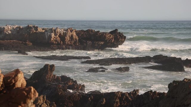 waves rolling into rocky coastline of Kammabaai Beach, Hermanus, South Africa