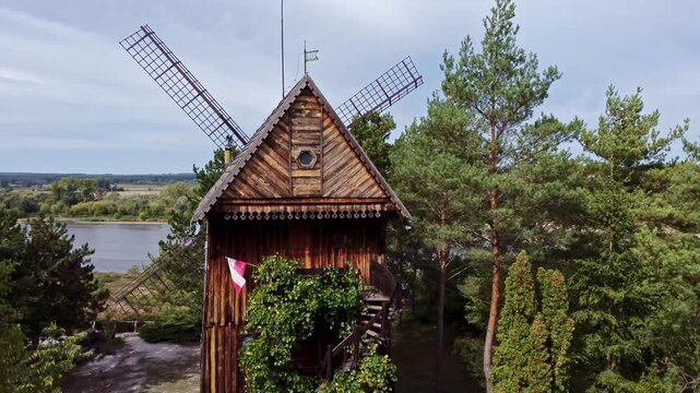 Majestic wooden windmill standing among pine trees near a river in kazimierz dolny, poland. Rural landscape showcasing traditional architecture. Kazimierz dolny, poland