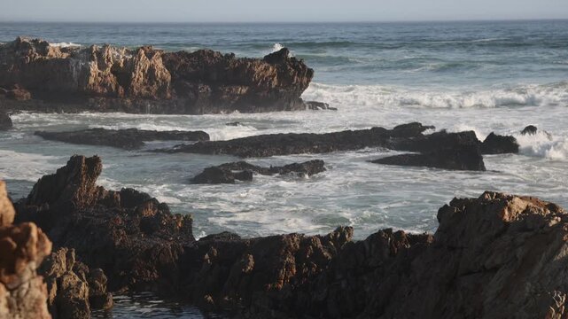 waves rolling into rocky coastline of Kammabaai Beach, Hermanus, South Africa