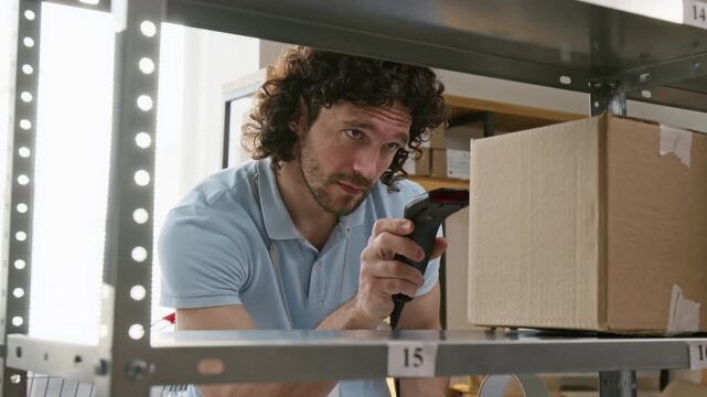Caucasian young man scanning parcel with barcode scanner and writing on clipboard in warehouse. Perfect for supply chain logistics, inventory management and order fulfillment marketing