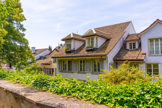 European Houses with Tiled Roofs, Dormer Windows and Lush Green. Old city architecture. Cityscape in Zurich Switzerland.