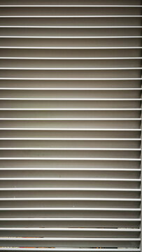 A clean, abstract background texture of parallel horizontal lines and slats on a louver or shutter surface