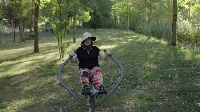 Senior Woman Exercising on Outdoor Fitness Equipment in Park
