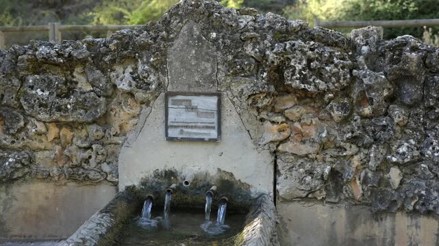Fresh Water Flowing From Spouts in an Ancient Stone Fountain
