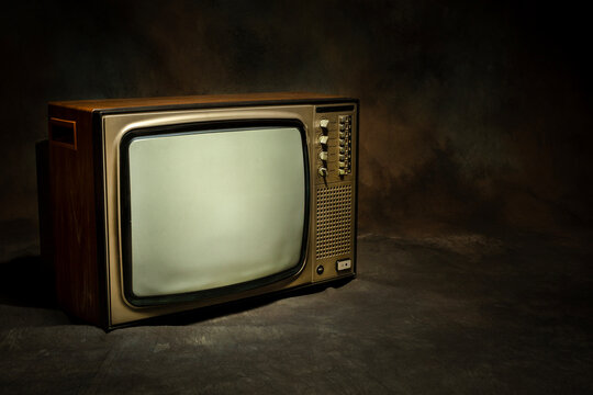 Retro old TV receiver with blank screen on a dark background.