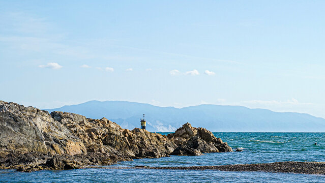 Rocky coastal outcrop and small lighthouse viewed from Ako, Hyogo