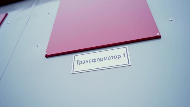 First transformer nameplate on electrical substation door closeup. Infrastructure for energy transmission and stable power supply