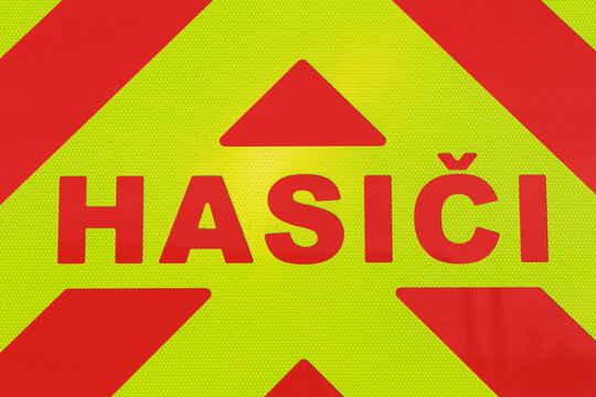 Hasici (translation from Czech: firemen). Detail of a red fire truck with reflective lettering. Public emergency services provided by firefighters and rescuers in the Czech Republic.