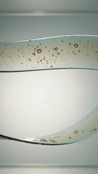 Vertical video: Sliding top ribbon making pale ribbons twisting, crossing on lightbox, with bubbles