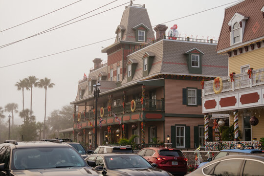St. Augustine,FL,USA - Dec.30.2024: Historic hotels in downtown St. Augustine, Florida, display wreaths, lights, and colorful Christmas ornaments. Cars fill the street as palm trees fade into the