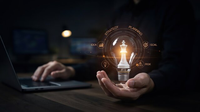 Businessman holding a glowing light bulb with a chess king piece inside, surrounded by business strategy icons representing planning, idea, goal, and risk