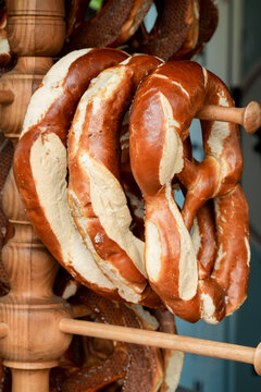 Fresh pretzels hanging on a wooden stand in a bakery, illustrating traditional Oktoberfest food culture.