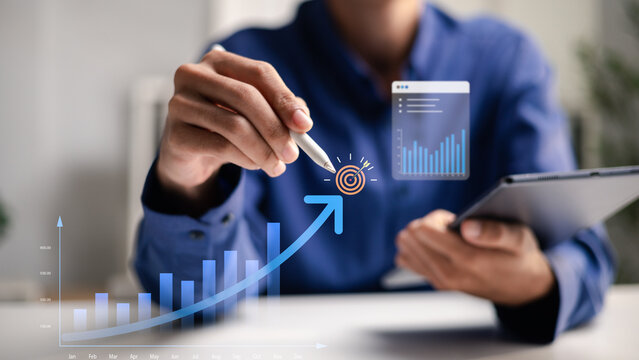 A business analyst uses a tablet to plan measurable growth and targets. The image represents performance analytics, KPI tracking, revenue strategy and data-driven business success.