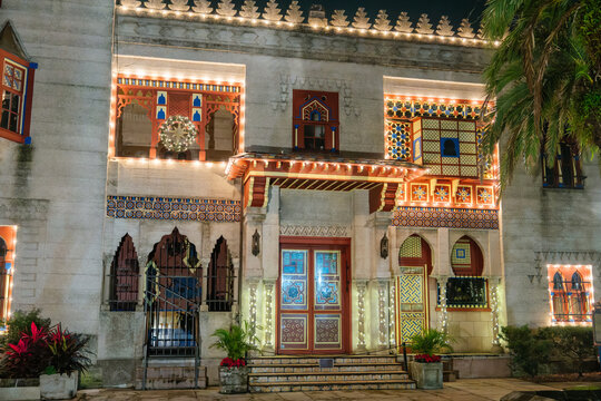 The entrance of Villa Museum features colorful Moorish arches, mosaic tiles, and geometric patterns. White Christmas lights and a glowing wreath illuminate the historic St. Augustine landmark at night