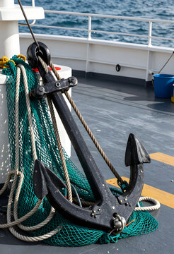 Maritime stability and security, heavy metal anchor with fishing nets and ropes on a ship deck for nautical travel and commercial fishing industry