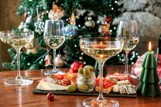 Festive Holiday Table With Champagne Glasses, Charcuterie Board, Poinsettia and Christmas Candles
