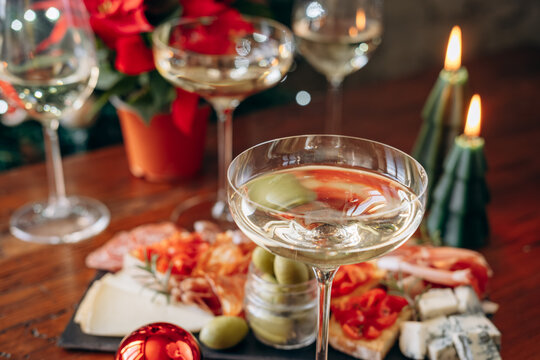 Festive Holiday Table With Champagne Glasses, Charcuterie Board, Poinsettia and Christmas Candles
