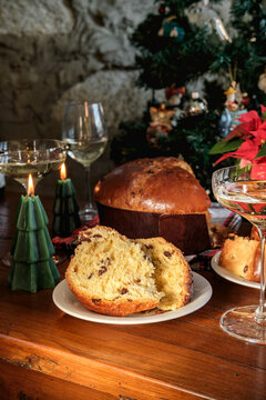 Festive Christmas Table With Sliced Panettone, Champagne Glasses, Poinsettia and Holiday Candles