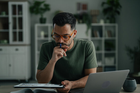 Man wearing glasses concentrating on remote work in home office