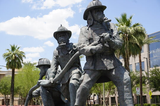 Statue of firefighters with a firehose at the Arizona Fallen Firefighters and Emergency Paramedics Memorial on Wesley Bolin Memorial Plaza in Phoenix, Arizona