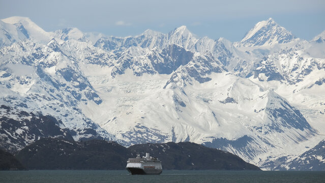 Breathtaking mountain glacier range view with luxury cruiseship cruise ship liner Zaandam Volendam sailing in front of Alaska mountains with spectacular landscape scenery Endicott Arm Fjord