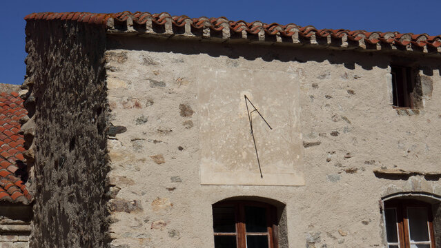 Cadran solaire compos&eacute; d'une plaque et d'une tige m&eacute;tallique, gnomon, indiquant l'heure. Il est 12h15.