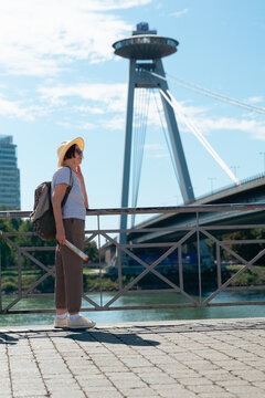 elderly tourist woman looking at SNP bridge in Bratislava Slovakia landscape background for designer template mockup concept of travel, tourism, architecture