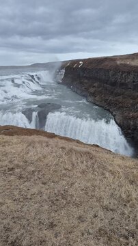 Gullfoss waterfall cascading in Iceland under cloudy sky on a moody day