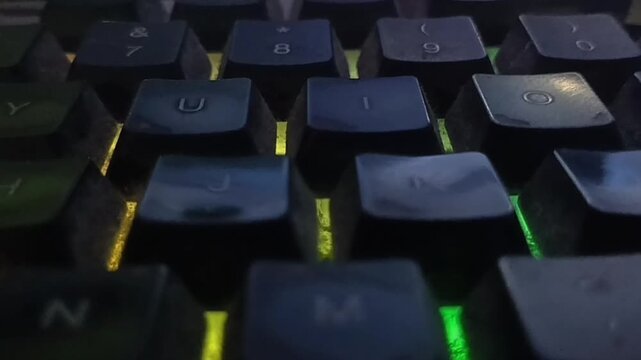 Close-Up of RGB Mechanical Gaming Keyboard with Rainbow Backlighting in the Dark