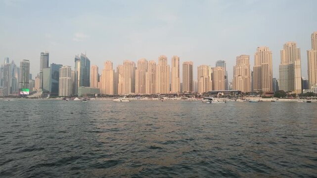Side tracking shot from cruising boat showing famous Jumeirah Beach Residence skyline Dubai