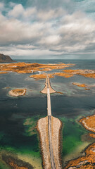Vertical aerial view of narrow coastal road and bridges connecting rocky islands in fjord in Lofoten Norway © Quality by Simon