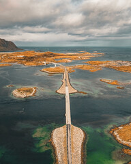 Vertical aerial view of narrow coastal road and bridges connecting rocky islands in fjord in Lofoten Norway © Quality by Simon