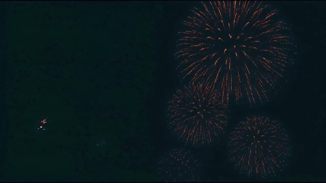 Golden fireworks exploding in the dark night sky with copy space for celebration and holiday events