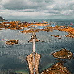 Panoramic aerial view of coastal road and bridges connecting rocky islands in fjord under cloudy sky in Lofoten Norway © Quality by Simon
