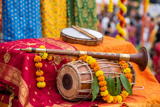 Traditional musical instruments displayed against vibrant fabrics during Dussehra celebrations in a close-up shot with natural lighting and soft background blur