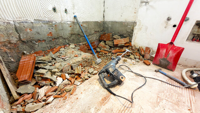 Home interior renovation and bathroom demolition with power tools shovel and rubble