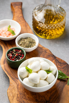 Mozzarella Balls with Olive Oil and Spices on Rustic Wooden Board