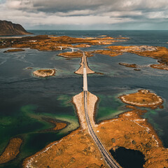 Vertical aerial view of long coastal road and bridges connecting rocky islands in fjord in Lofoten Norway © Quality by Simon