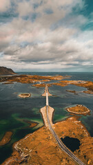 Vertical aerial view of long coastal road and bridges connecting rocky islands in fjord in Lofoten Norway © Quality by Simon