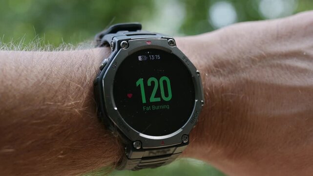 Smartwatch displaying fat burning zone heart rate 117 bpm on a male wrist