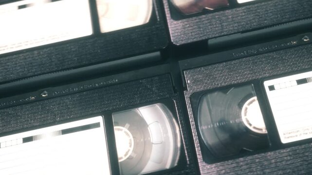 Close-Up Camera Movement Across Analog Video Tapes With Nostalgic Mood