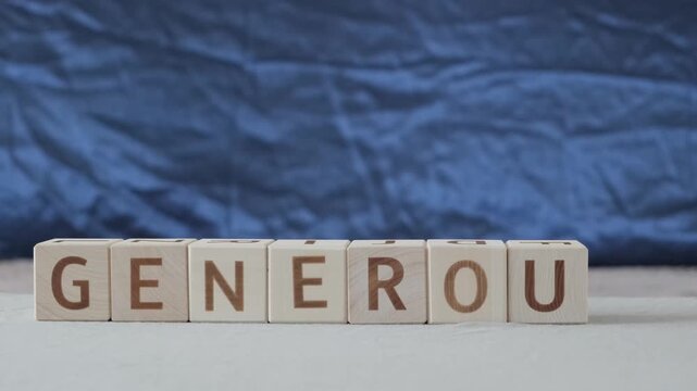 motivational word Generous, laying out  by hand from letters on wooden cubes, slow motion
