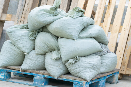 Construction debris in bags sits on a wooden pallet. Close-up.