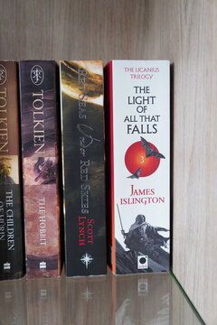 Fantasy book spines on a wooden shelf featuring works by J.R.R. Tolkien and James Islington